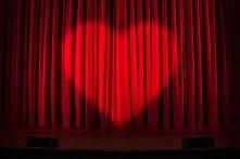 Roter Theatervorhang mit Spot in Form eines Herz