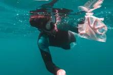 Man catching plastic under water