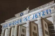 Brandenburger Tor angestrahlt mit Schriftzug "Nie wieder ist jetzt" und Judenstern