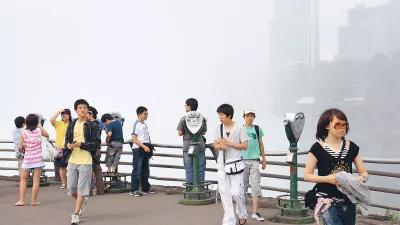 Menschen auf einem Aussichtspunkt, dahinter Smog