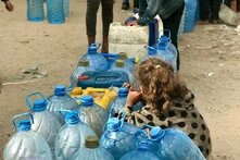 Child from behind with empty water bottles.