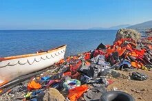 Flüchtlingsboot am Meeresufer und unzählige Schwimmwesten am Strand