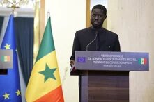 Foto: Präsident Bassirou Diomaye Faye spricht bei einer Veranstaltung in Dakar am Rednerpult. Im Hintergrund sind die Flaggen der EU und des Senegal.