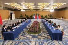 GPT  Foto: Große Konferenz mit Delegationen aus China (links) und Argentinien (rechts) an zwei langen Tischen. In der Mitte stehen die Nationalflaggen beider Länder.