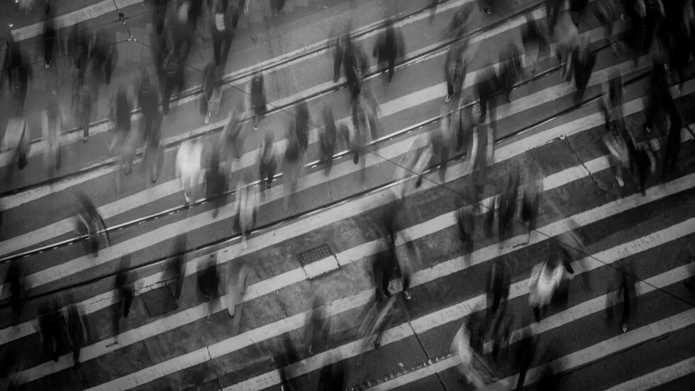 Viele Menschen laufen über eine Straße