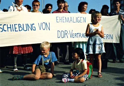 Kinder sitzen vor einem Banner, Demo gegen die Abschiebung von ehemaligen DDR-Vertragsarbeiter/innen