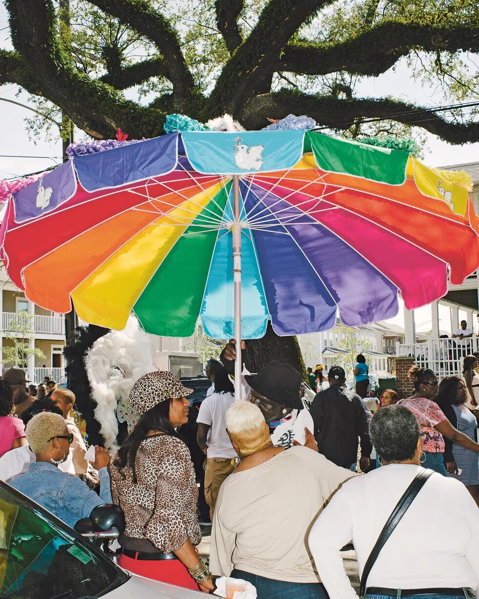 Menschen unter einem Sonnenschirm in Regenbogenfarben