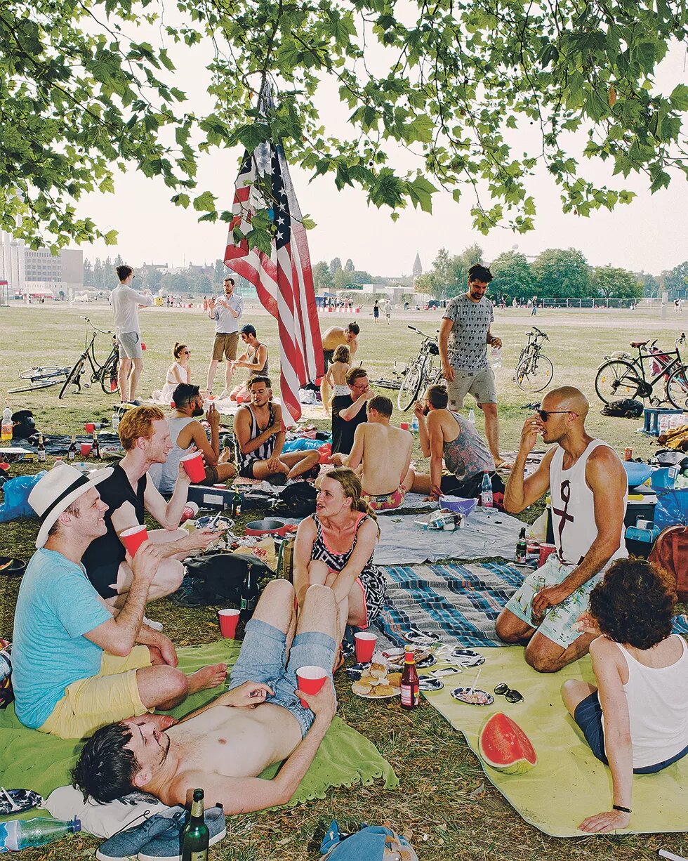 Mehrere Menschen picknicken unter einer US-Fahne
