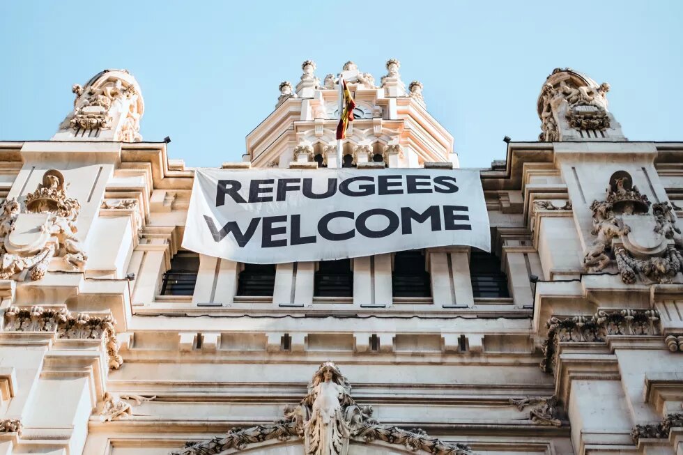 Ein Banner mit der Aufschrift "Refugees welcome" hängt am Rathaus von Madrid.