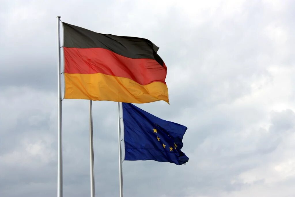 Eine Deutschlandflagge und eine EU-Flagge wehen im Wind