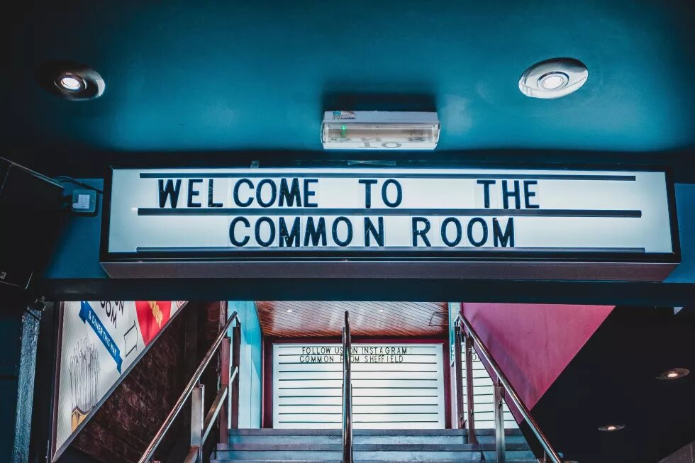 Schriftzug über einer Treppe: "Welcome to the common room"