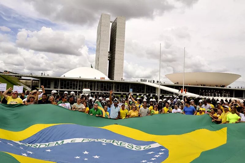 Menschen protestieren und halten die brasilianische Flagge