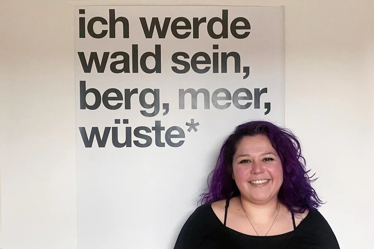 Mimi mit leuchtend lila Haaren beim Interview in einem Büro der Heinrich-Böll-Stiftung