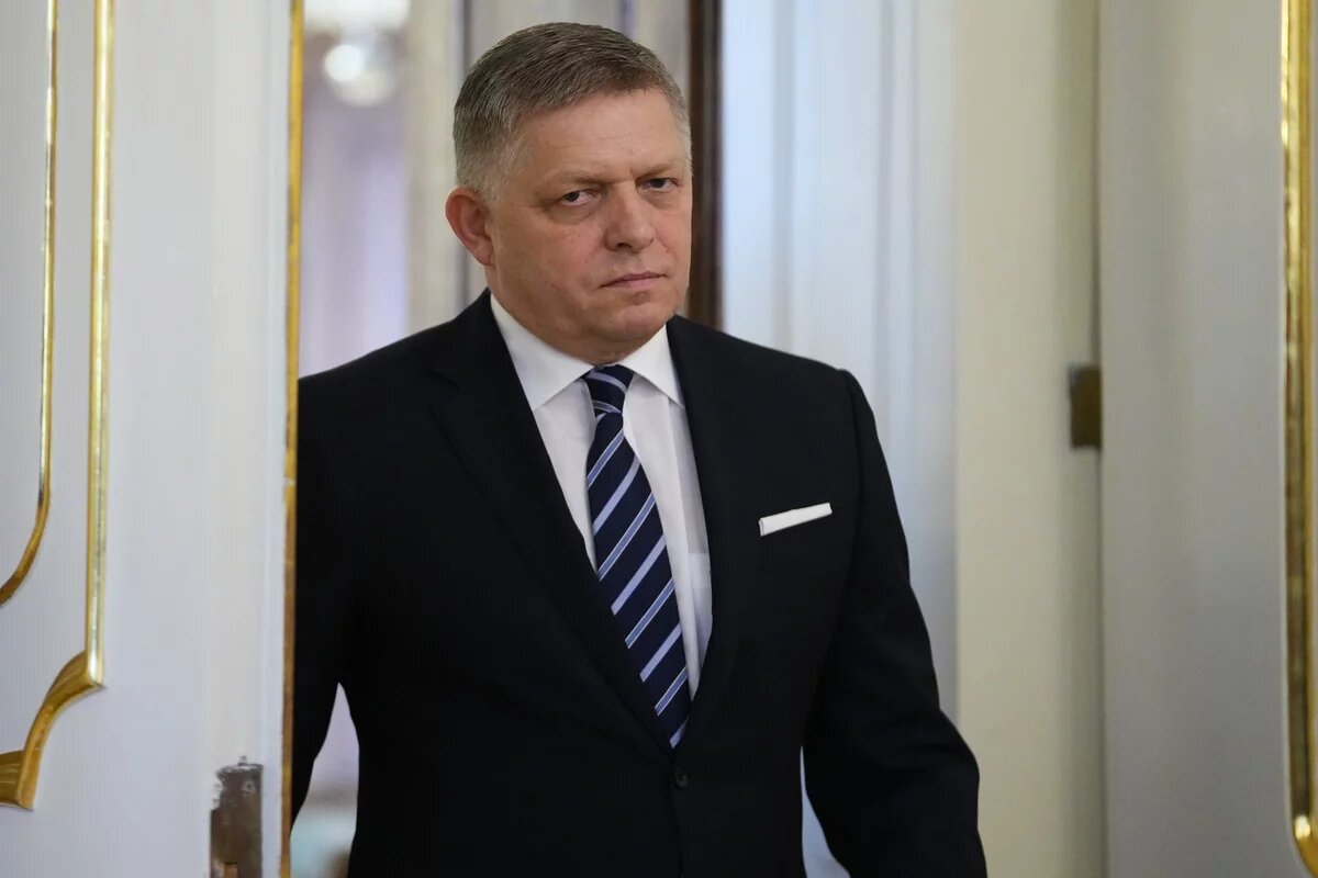 Porträt von Robert Fico, der gerade im Anzug durch eine Tür geht