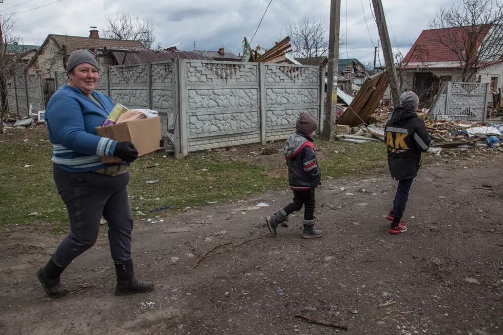 Eine Frau und zwei Kinder laufen durch Novoselivka, ein zerstörtes Dorf in der Ukraine.