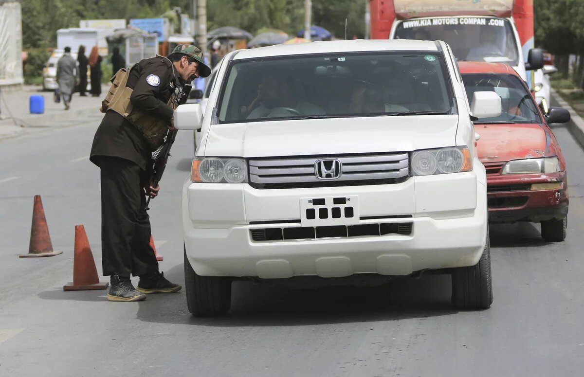 An Afghan security force member checks a vehicle in Kabul