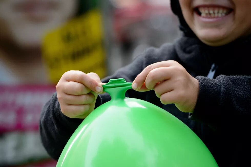 Kind mit grünem Luftballon