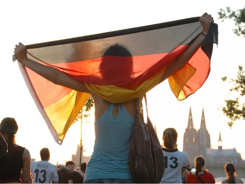 Ein Mädchen hält beim Public Viewing in Köln die deutsche Flagge empor