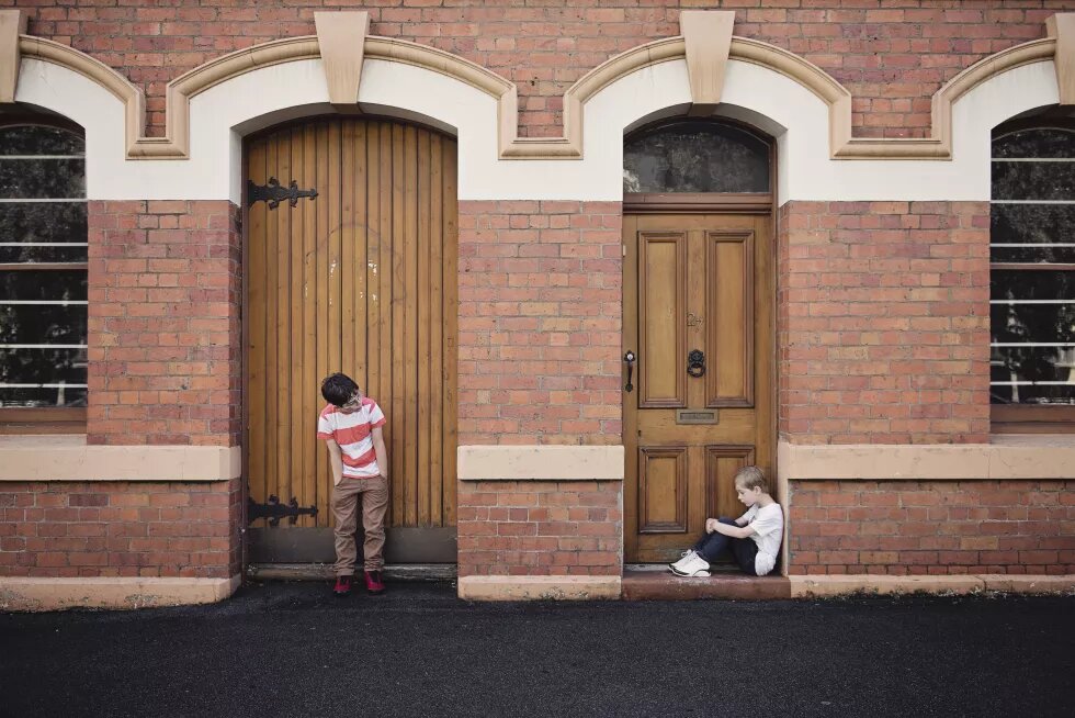 Zwei traurige Jungen vor geschlossenen Türen