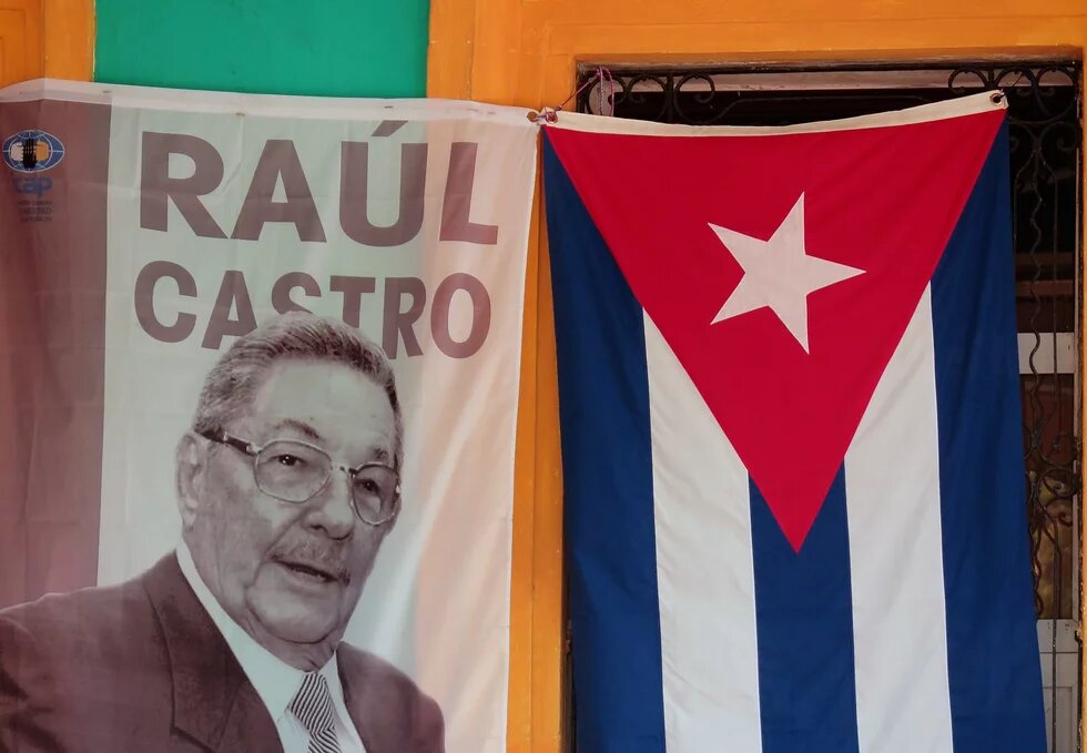 Raúl Castro auf einem Banner neben der cubanischen Flagge