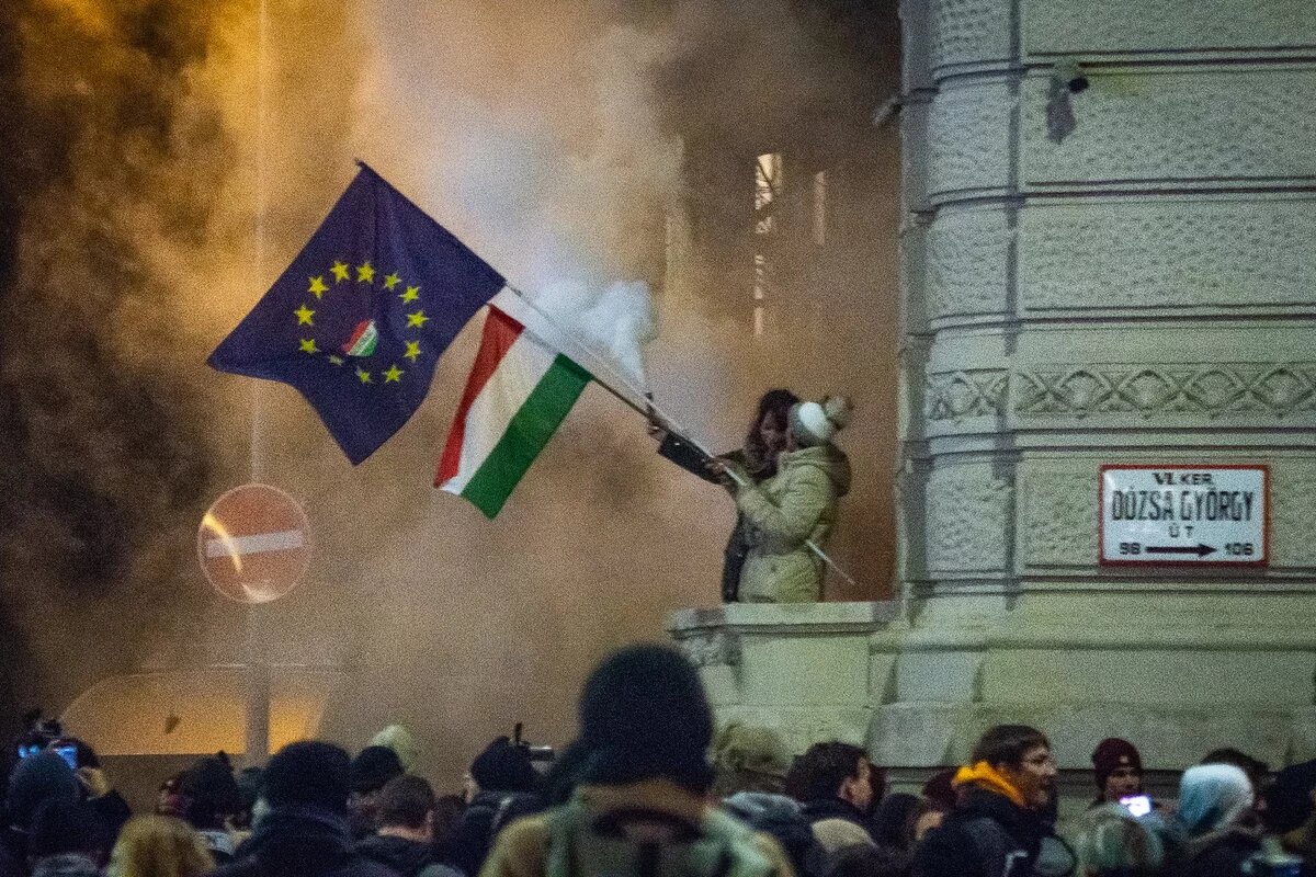 Protesters are waving an EU and a Hungarian flag