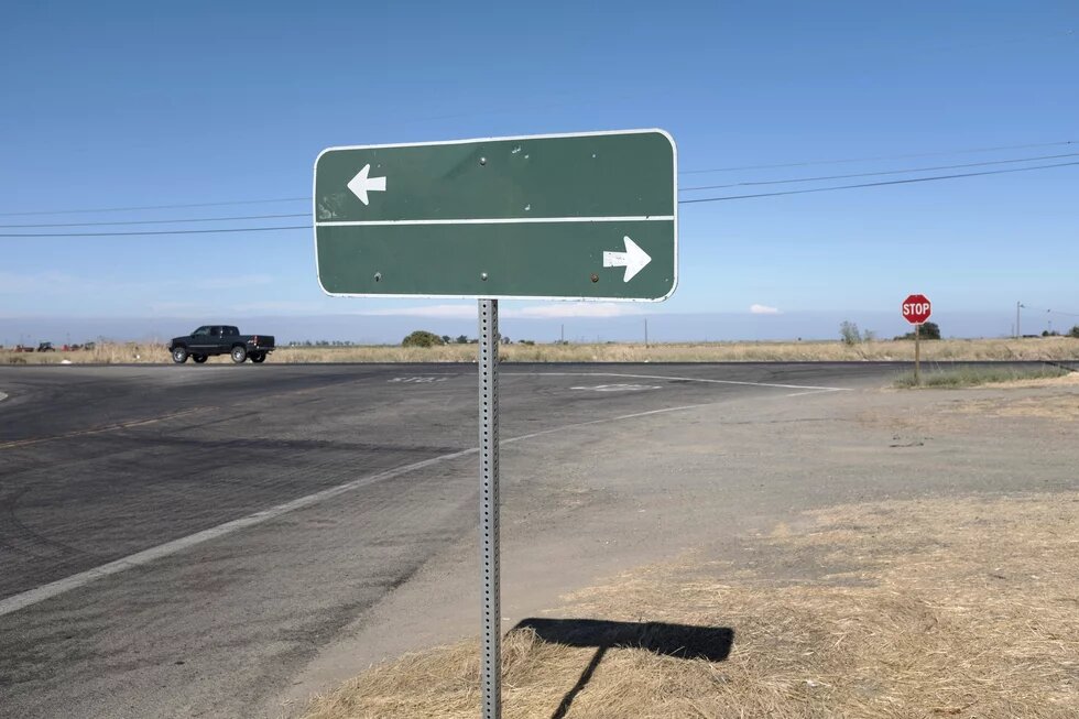 Ein grünes Straßenschild zeigt nach recht und links