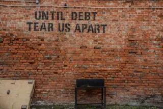 Eine Backsteinwand auf der in schwarzen Buchstaben steht: "Until Debt Tear us Apart"